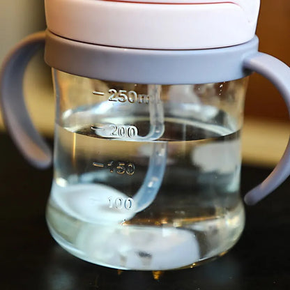 نصف كوب شرب وردي اللون للأطفال سعة 250 مل، مزود بماصة، يعمل بتقنية الجاذبية، ذو فتحة واسعة، مناسب لشرب الحليب والماء، مع مقبض. 