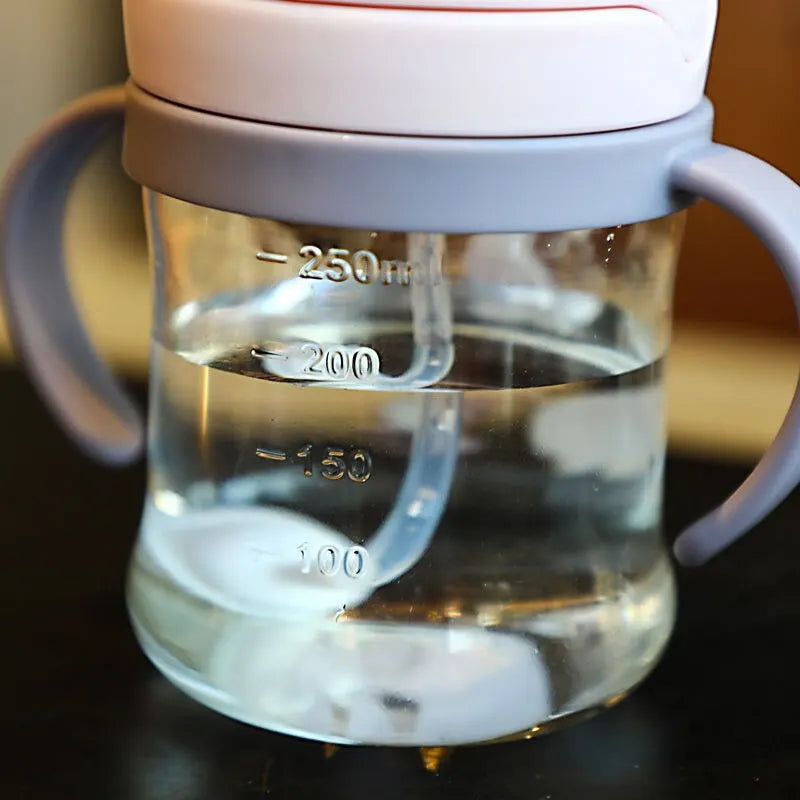 نصف كوب شرب وردي اللون للأطفال سعة 250 مل، مزود بماصة، يعمل بتقنية الجاذبية، ذو فتحة واسعة، مناسب لشرب الحليب والماء، مع مقبض. 